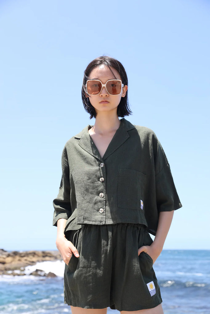 Woman wearing a green linen short sleeve shirt made by LF Markey