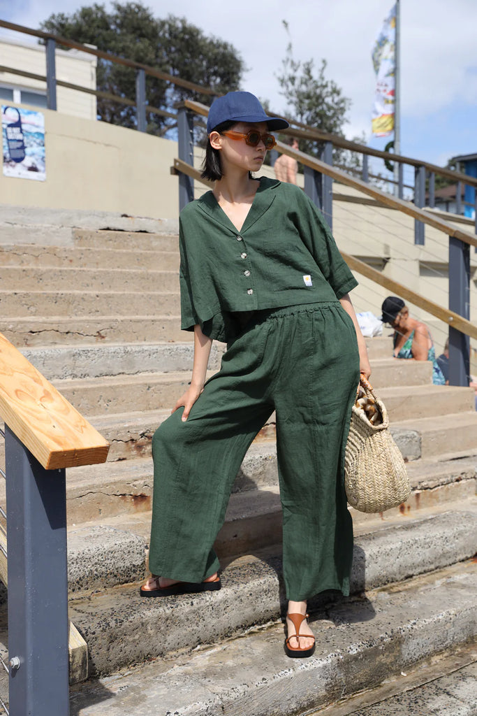 Woman wearing a green linen short sleeve shirt made by LF Markey