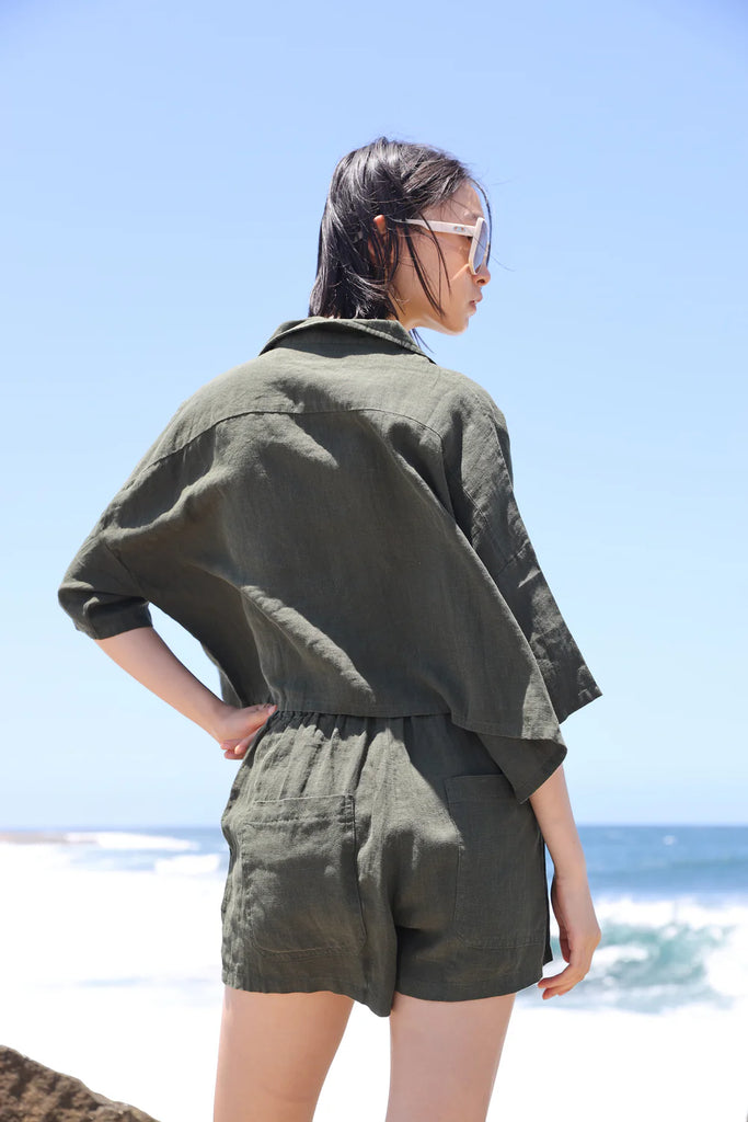 Woman wearing a green linen short sleeve shirt made by LF Markey