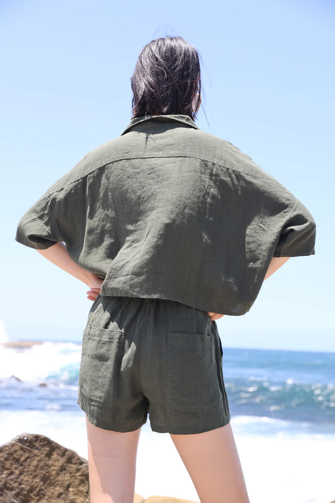 Woman wearing a green linen short sleeve shirt made by LF Markey