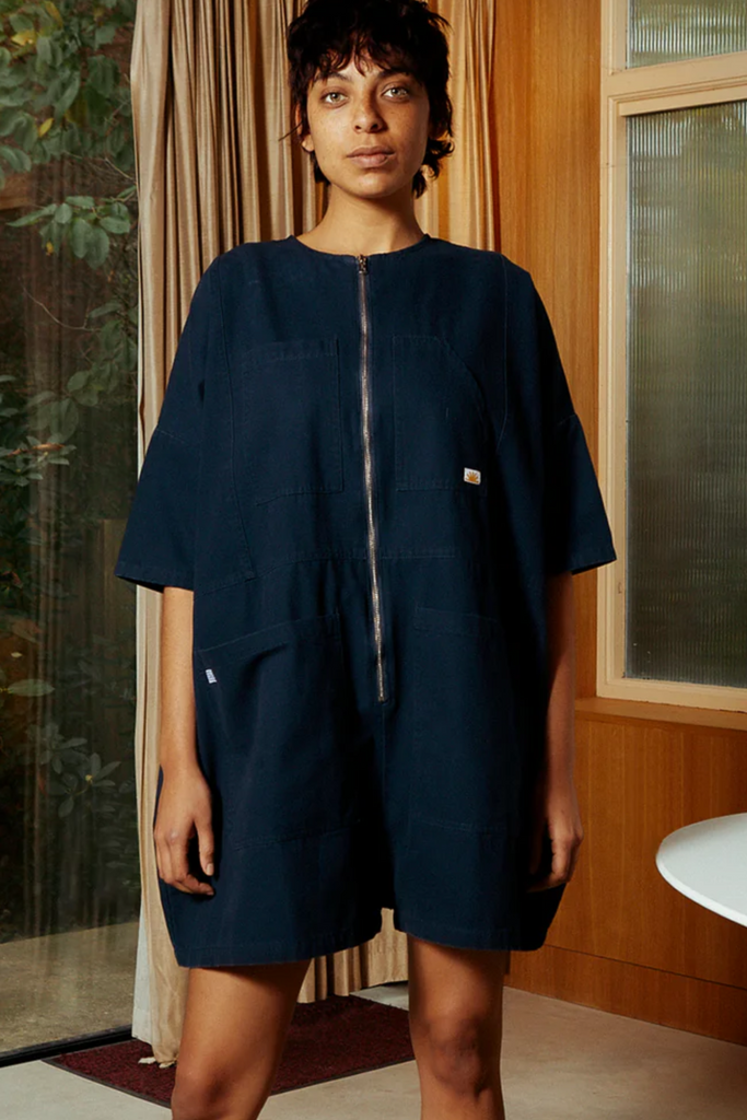 Woman wearing a navy blue jumpsuit made by designer LF Markey. 