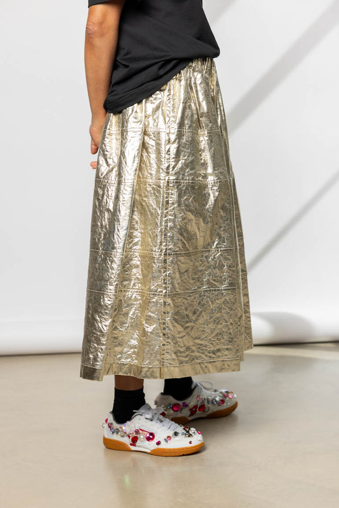 Person wearing a metallic gold skirt 